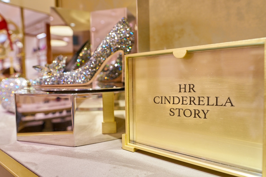 Jeweled high heel shoe next to a gold box labeled "hr cinderella story"