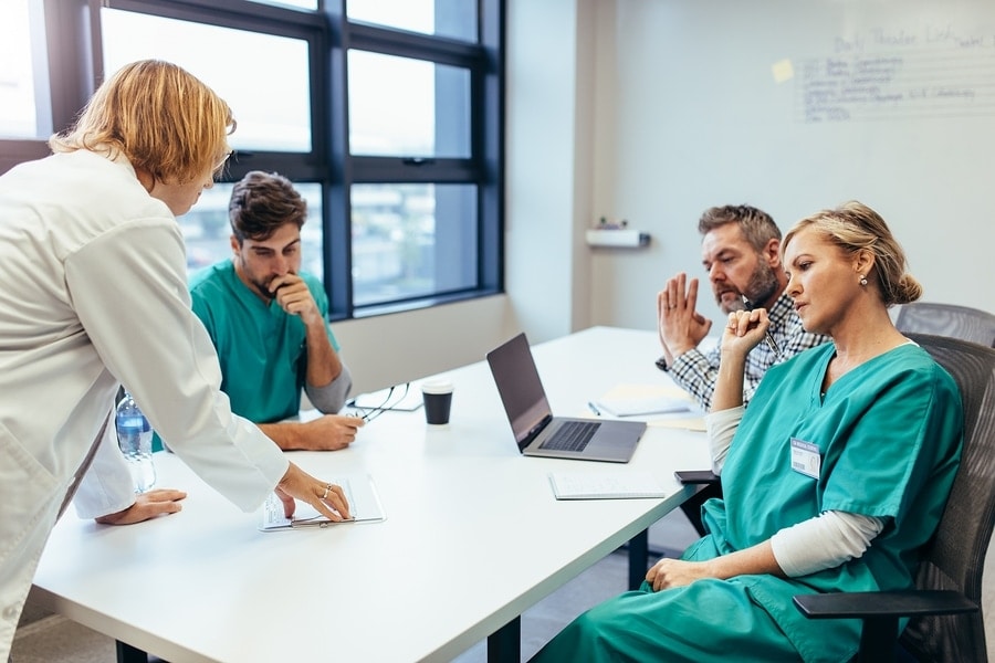 Group of medical professionals brainstorming in a meeting. Team of healthcare workers discussing in boardroom with female doctor presenting her plan.